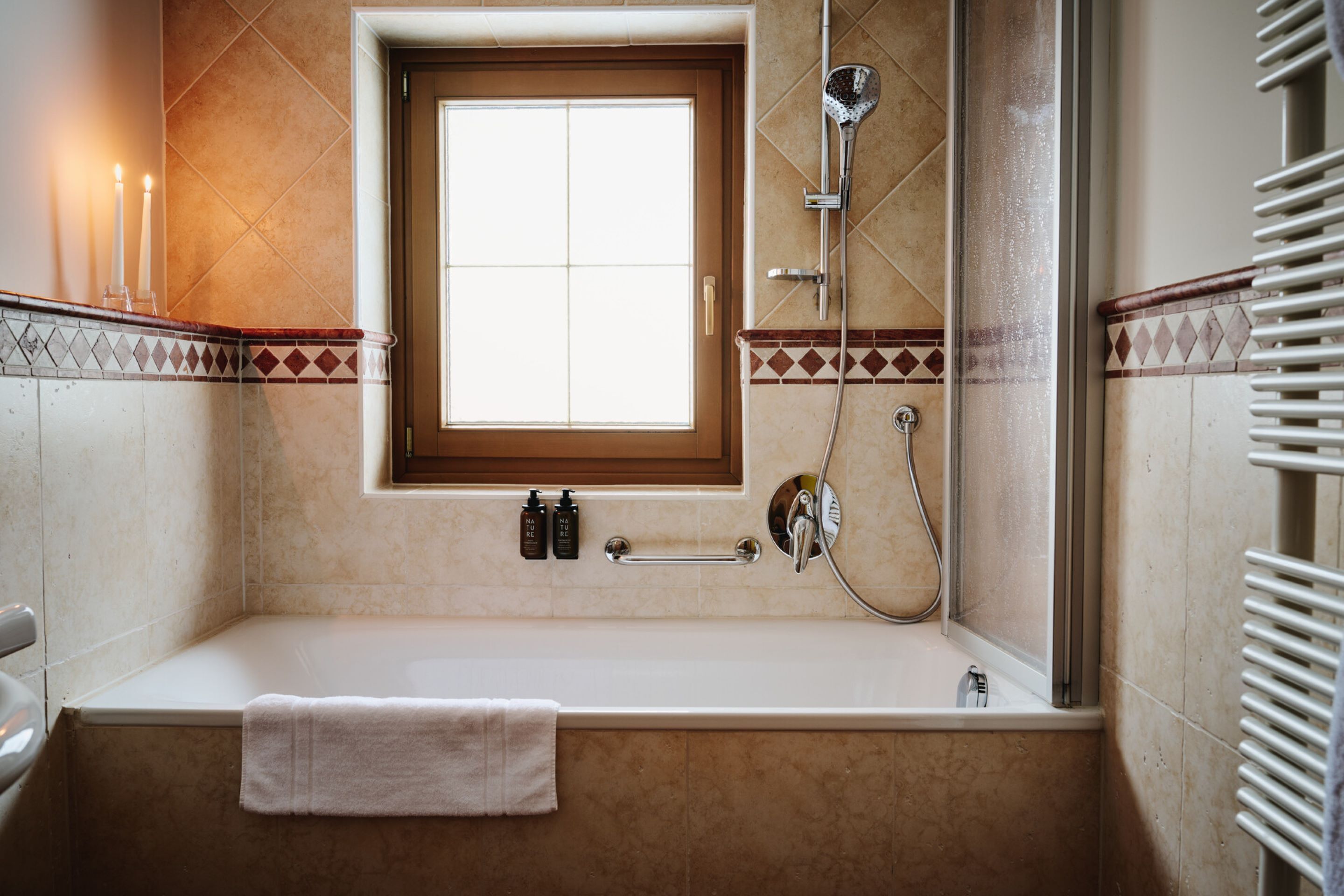 Un baño con bañera, ventana y ducha.