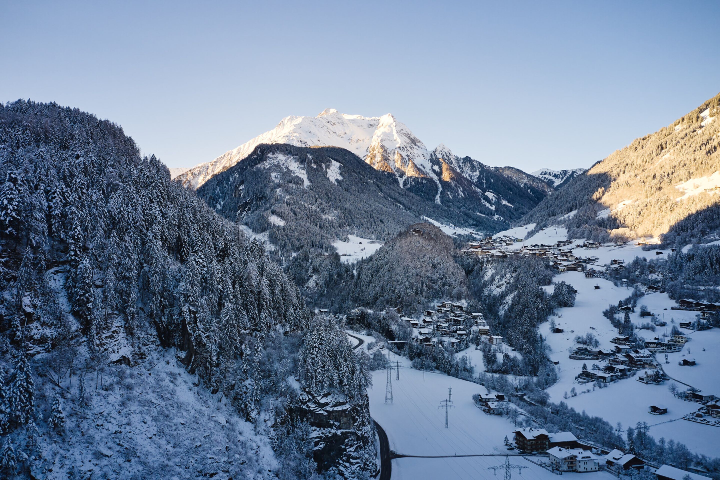 Un paisaje montañoso cubierto de nieve con un pueblo enclavado en el valle.