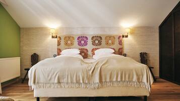 Un dormitorio amplio con una cama grande, dos mesitas de noche y un cabecero decorativo.