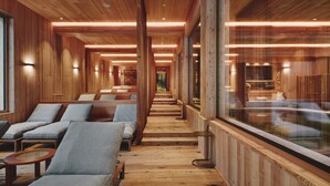 Un interior de madera con sillones reclinables y un muro de cristal.