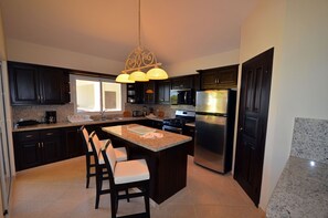 Kjøleskap, kjøkkenutstyr og spisebord