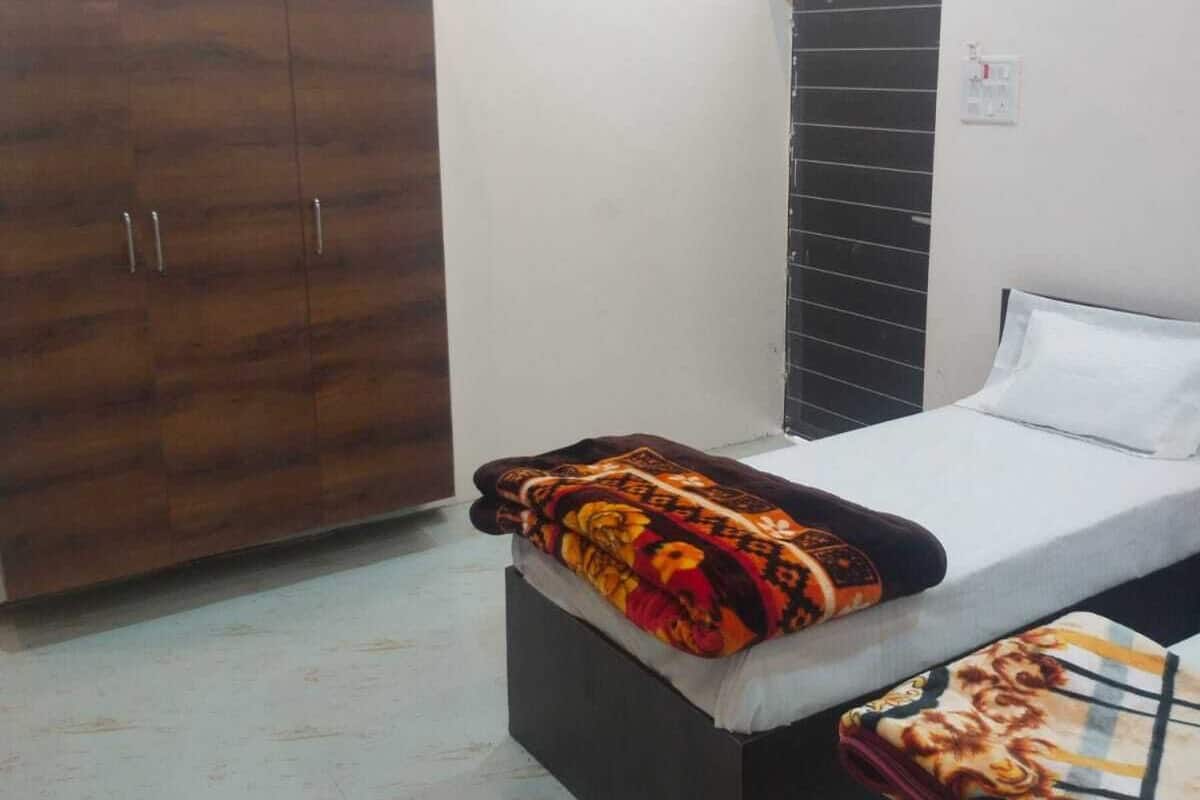 Un dormitorio con cama, armario y ventilador de techo.