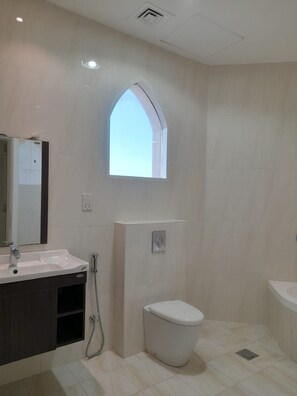 A bathroom with a white toilet, a sink, and a shower. - Holiday Villa Ras Al Khaimah (Ras Al Khaimah)
