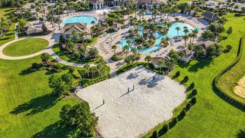 A golf course with a large pool area, multiple buildings, and well-maintained landscaping.