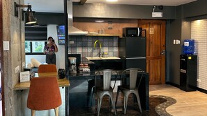 A modern kitchen with a central island, bar stools, and a seating area with a rug. - Blue Tulip (Lapu-Lapu)