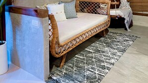 A cozy room with a wicker sofa, a hanging swing, and a large air conditioning unit mounted on the wall. - Blue Tulip (Lapu-Lapu)
