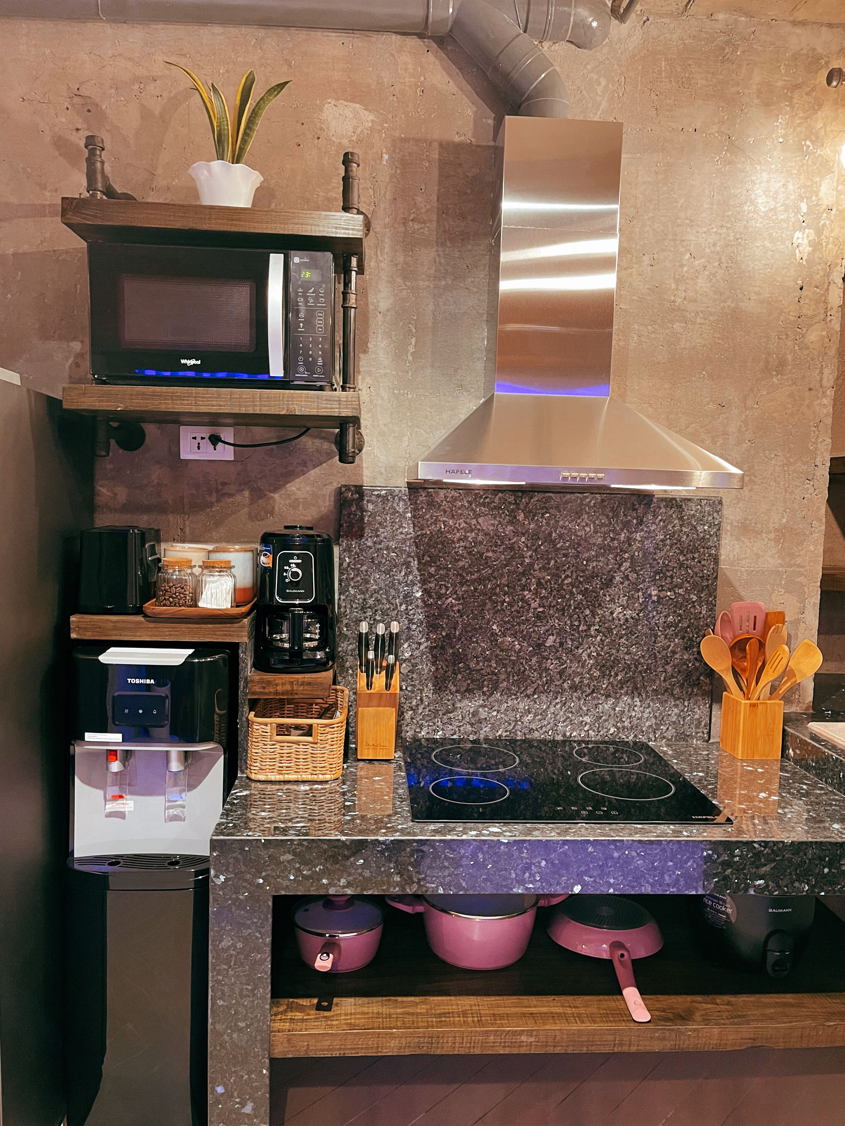 Une cuisine équipée d’un four à micro-ondes, d’un grille-pain, d’une machine à café et d’un distributeur d’eau.