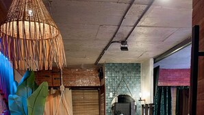 A modern interior with a dining area, a hanging chair, and a kitchen area with a tiled backsplash. - Blue Tulip (Lapu-Lapu)