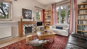 A living room with a fireplace, bookshelves, a sofa, and a coffee table.