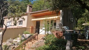 A house with a covered porch, a chimney, and a stone staircase leading to the entrance.