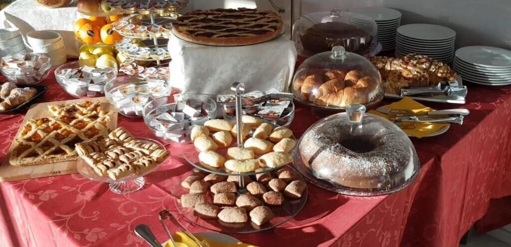 Ein Buffet mit verschiedenen Backwaren, darunter Kuchen, Gebäck und Brot.