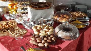 Ein Buffet mit verschiedenen Backwaren, darunter Kuchen, Gebäck und Brot.