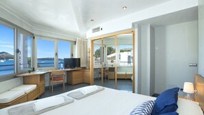 A modern hotel room with a large bed, a desk, a TV, and a view of the sea. - Magnific Apt 2 Sea View by JS Villas (Puerto Pollensa)
