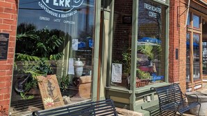 A storefront with a sign reading "Harbor Perk" and a menu board advertising coffee and espresso.