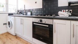Une cuisine moderne équipée d’un lave-linge, d’un four et d’un four à micro-ondes.