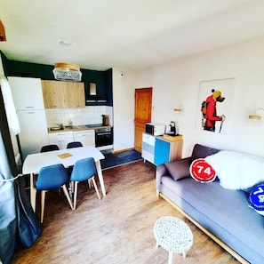 A compact living space with a kitchenette, a dining area, and a sofa. - Apartment at the foot of the gondola with swimming pool (Saint-Gervais-les-Bains)