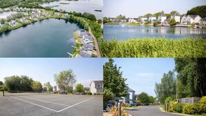 A lakeside residential area with houses, a tennis court, and a boat dock.