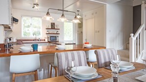 A modern kitchen with a central island, wooden chairs, and a dining table set for six. - Spring Lake 14, Lakeside Retreat - Waterside Lodge, Watersports, Sleeps 6 (South Cerney)