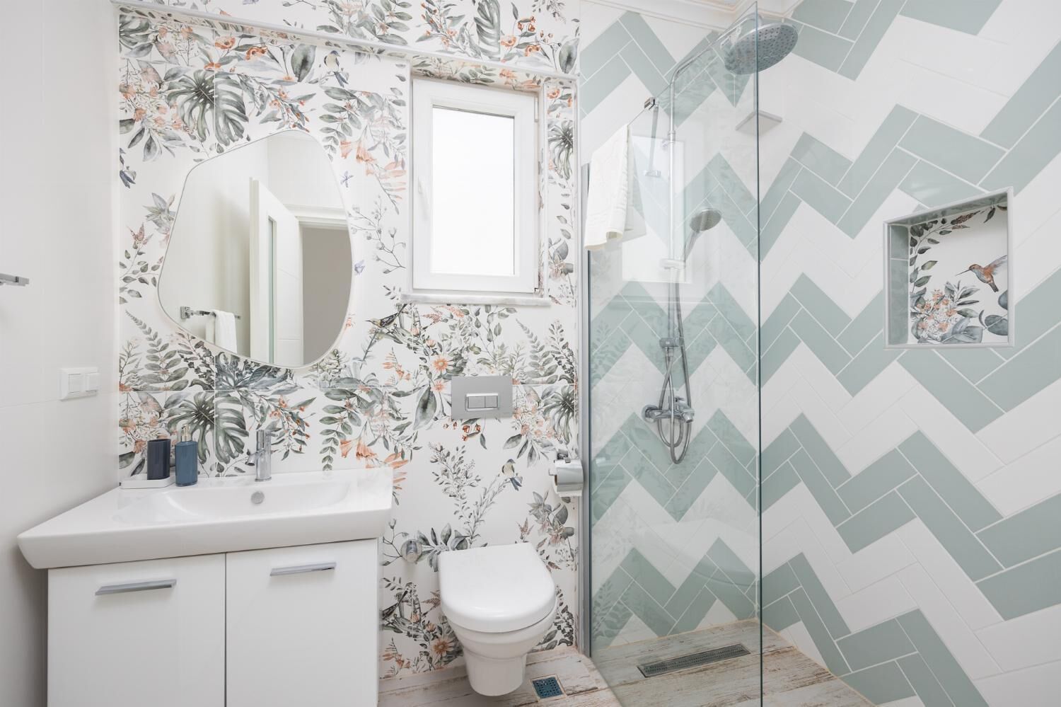 A bathroom with a shower, a toilet, a sink, and a mirror.