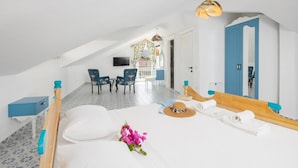Una camera da letto con un letto, una scrivania, due sedie, una televisione e un bagno con la porta blu.