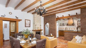 Comedor con una mesa de madera dispuesta para cuatro personas, rodeado de sillas tapizadas en tono marrón.
