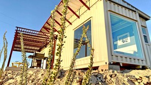 Een modern gebouw met een groot raam, een metalen dak en een stenen fundering.