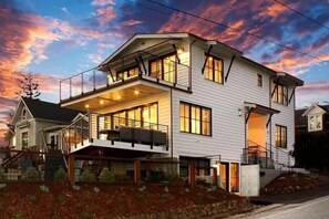 A two-story house with a balcony and a covered porch.