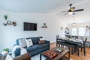Un salon moderne avec un canapé, une table basse et un coin repas.