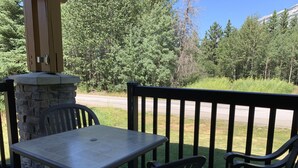 Un patio al aire libre con un pilar de piedra, una mesa y dos sillas.