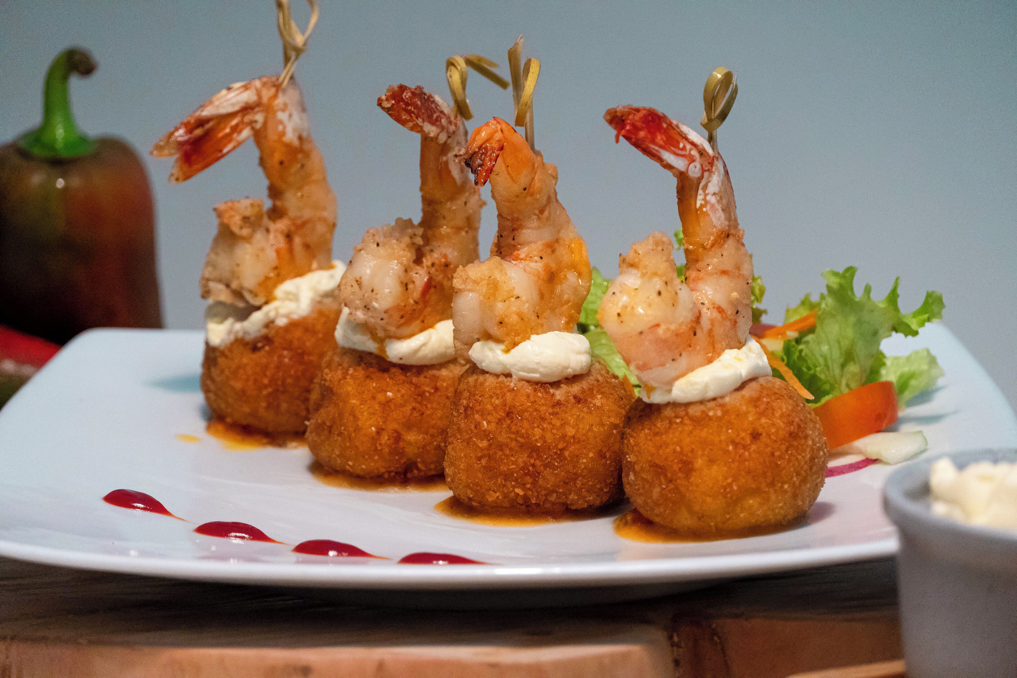 Une assiette de croquettes aux crevettes, accompagnée d’une salade.