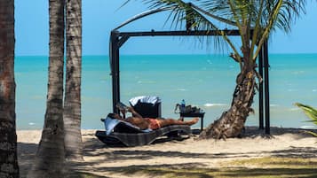 På stranden, parasoller, strandhanddukar och massage på stranden