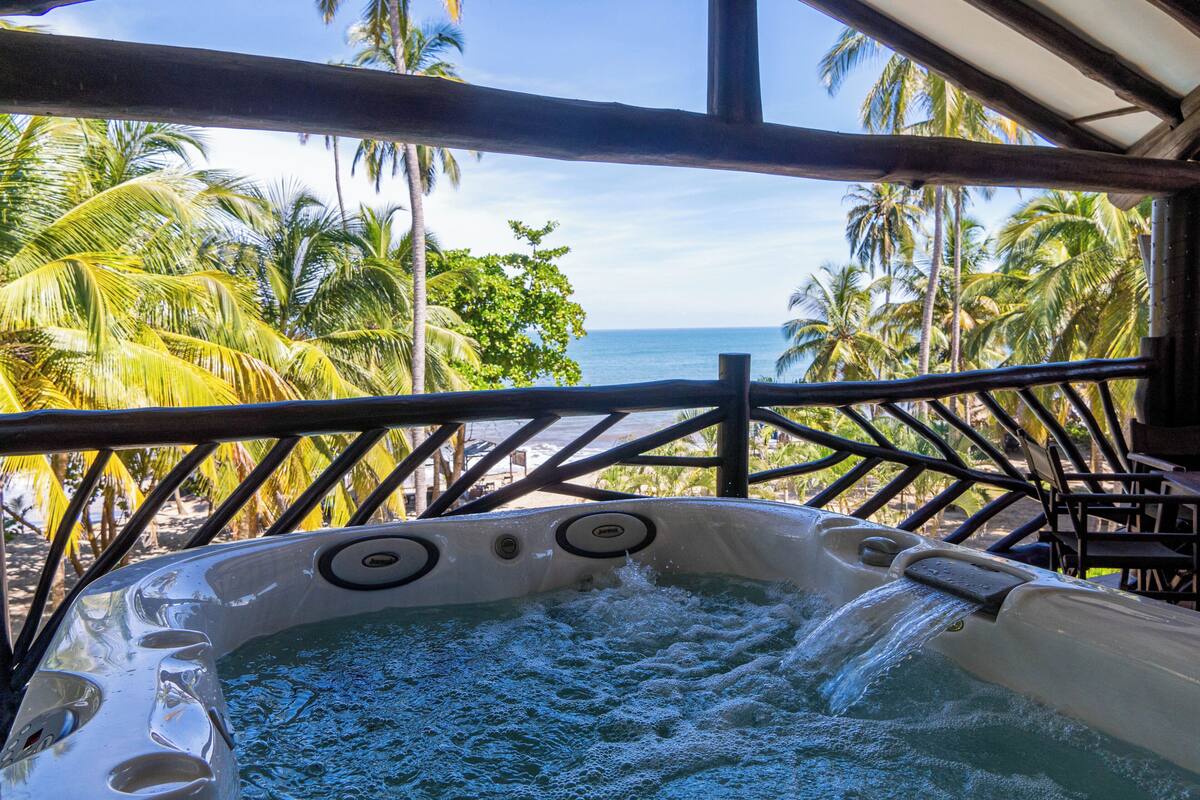Un jacuzzi con vista al océano y palmeras.