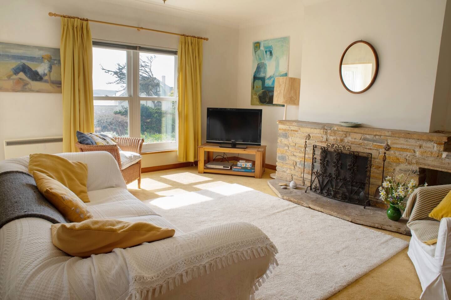 Une chambre à coucher avec un lit, une télévision, une cheminée et une fenêtre avec des rideaux.