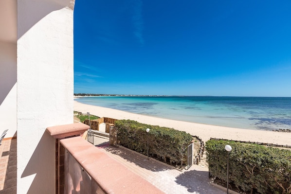 A balcony with a view of a beach and ocean.