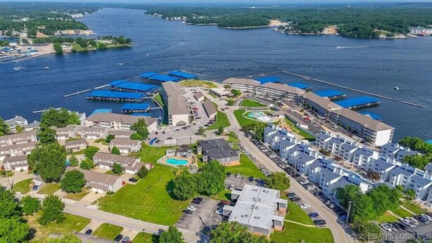 Vista aérea de una zona residencial costera con casas, un puerto deportivo y una piscina.
