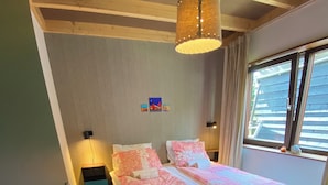 A bedroom with a large bed, two bedside tables, a hanging light fixture, and a window with curtains. - Central, cosy and modern appartment in Houseboat. Amsterdam Pur Sang. (Amsterdam)