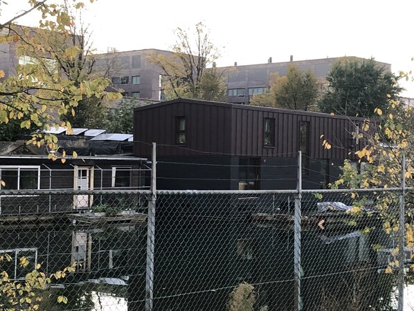 Un espace clos délimité par une clôture, avec un bâtiment à l’extérieur sombre et doté de nombreuses fenêtres.