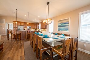 A spacious kitchen with wooden cabinets, a central island, and a dining area with blue tableware.