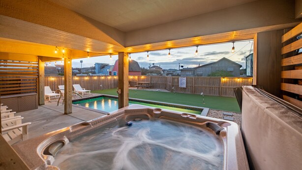 A hot tub area with a view of a backyard and houses. - Steps to the Sand-Ocean Views-Hot Tub/Heated Pool-Putting Green-Coffee Bar (Kitty Hawk)