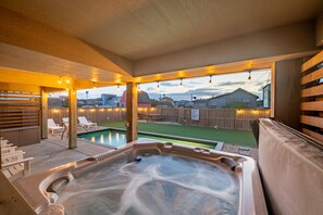 A hot tub area with a view of a backyard and houses.