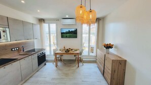 A modern kitchen with a dining area, wooden cabinets, a built-in oven, and a large window with a view. - Ze Perfect Place - Opera Nice - Apartment 2 Bdrms - AC - Terrace (Nice)