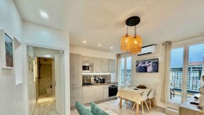 A modern kitchen with a dining area, a sofa, and a balcony with a view. - Ze Perfect Place - Opera Nice - Apartment 2 Bdrms - AC - Terrace (Nice)