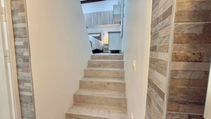 A staircase leading to a bedroom with a bed and bedside table. - Ze Perfect Place - Opera Nice - Apartment 2 Bdrms - AC - Terrace (Nice)