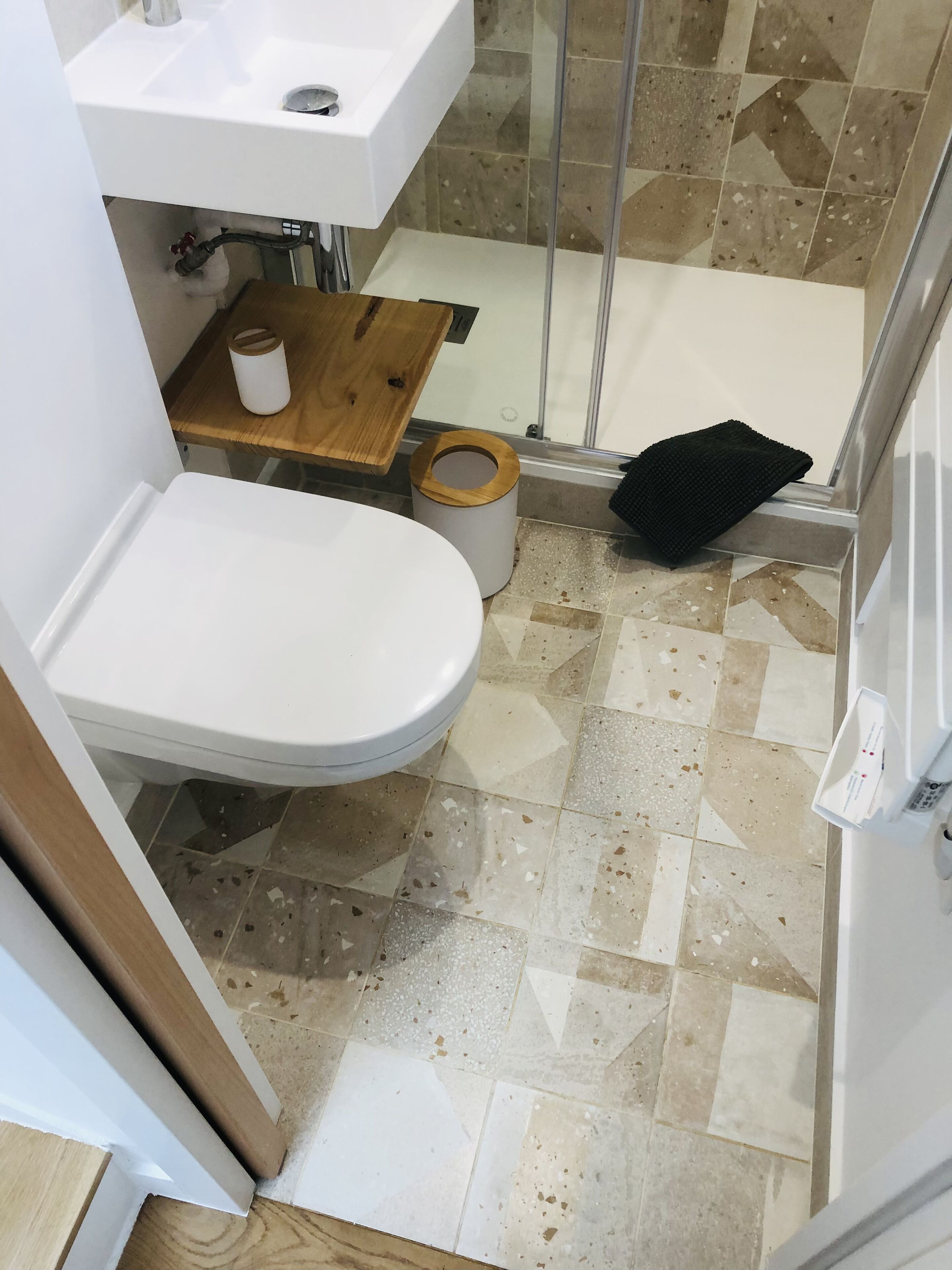 Une salle de bain comprenant des toilettes, un lavabo, une douche et un porte-serviettes.
