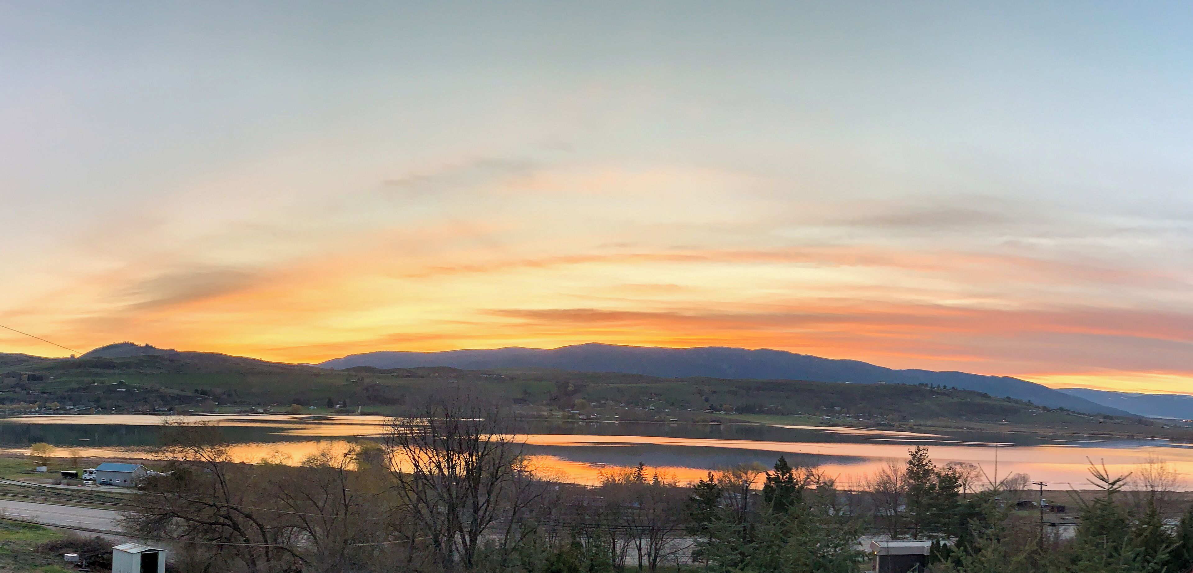 A landscape with a lake, hills, and a clear sky.