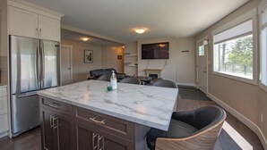 A modern kitchen with a marble island, built-in appliances, and a seating area with a fireplace. - Newly renovated with Lakeviews, big yard, minutes to Silver Star/Golf/Wineries. (Vernon)