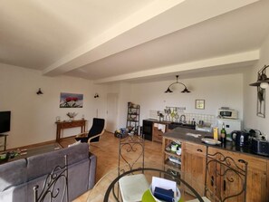 A spacious living area with a sofa, a dining table, and a kitchen in the background.