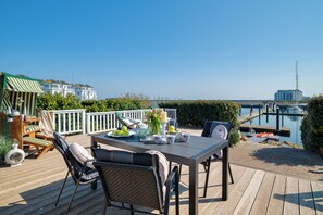 Outdoor dining - Wooden holiday home "Bootshaus" with sauna, bathing jetty and south-facing terrace with Baltic Sea view (Olpenitz)