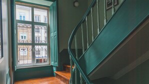 A wooden staircase with white balusters leading to a landing. - Vila Santa Cruz Guest House (Braga)
