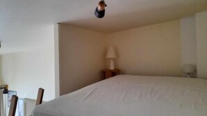 A bedroom with a large bed, a nightstand with a lamp, and a ceiling light fixture. - The DRYADES Mountain view (Gérardmer)